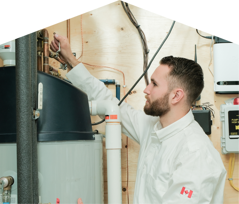 Mr. Furnace water heater specialist adjusts piping on a large residential unit during a repair service, with exposed wood paneling and mounted utility components in the background.